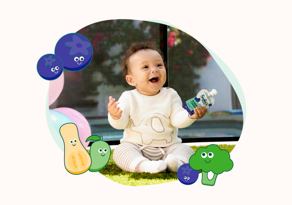 Happy baby holding Sophie's Organics Berry Cool organic baby food pouch outdoors.